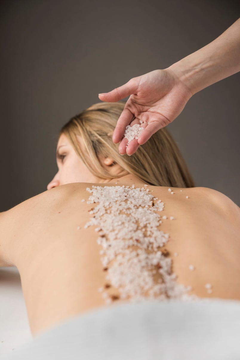 close up therapist hand applying salt woman s back